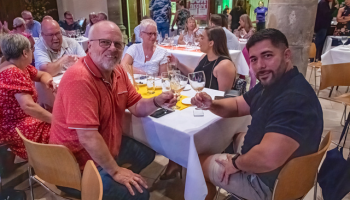 two men holding glasses of wine and smiling